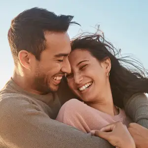 A happy couple hugging and smiling at each other