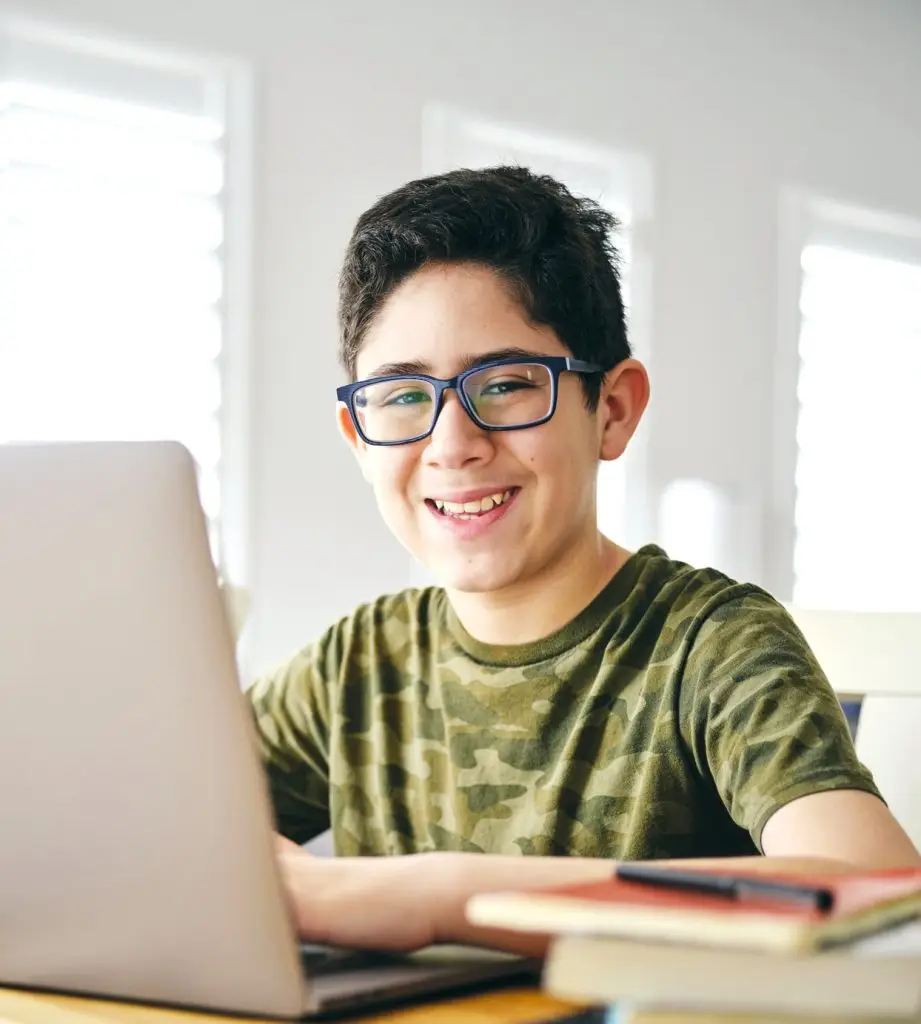 A student learning by doing schoolwork at home using a computer.