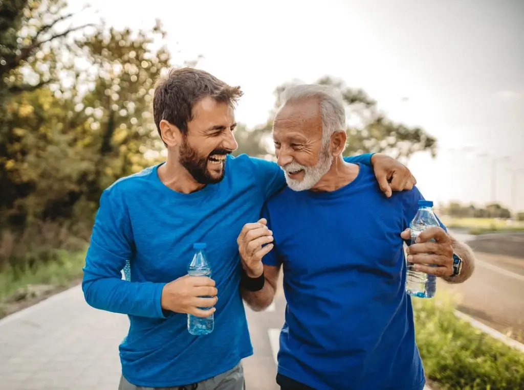 Two happy men laughing on a walk outdoors.