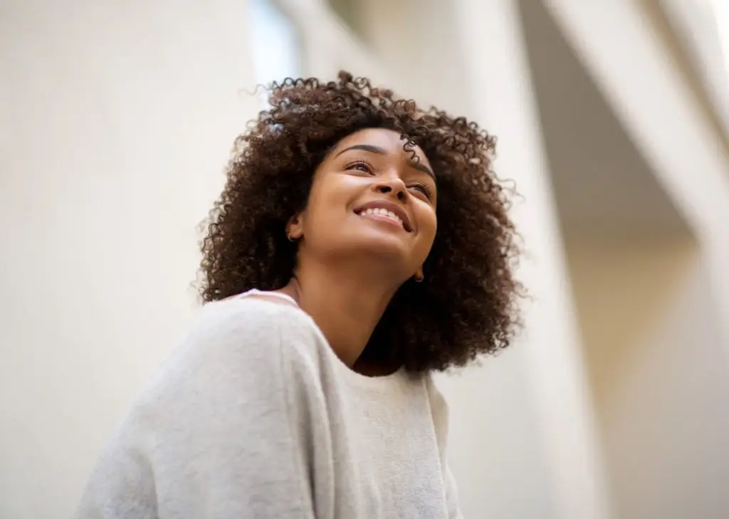 EMDR Therapy. Close up portrait of happy african american woman with curly hair smiling outside