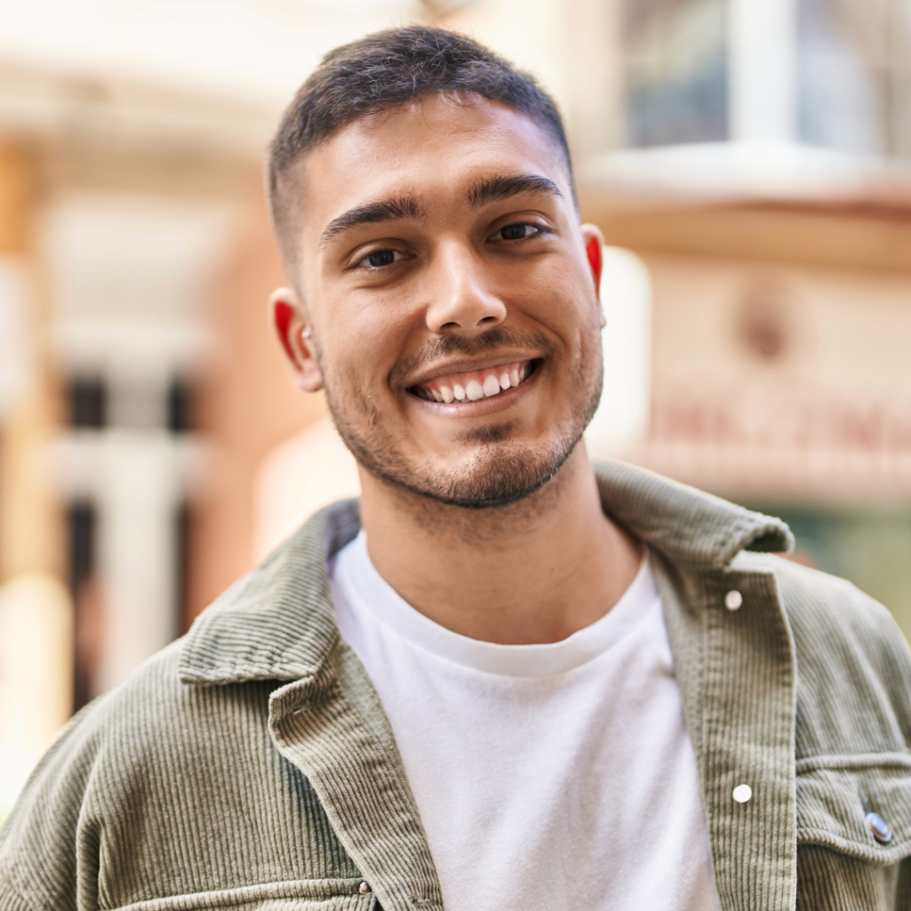 DBT Therapy. A man with short hair standing in front of a building and smiling.