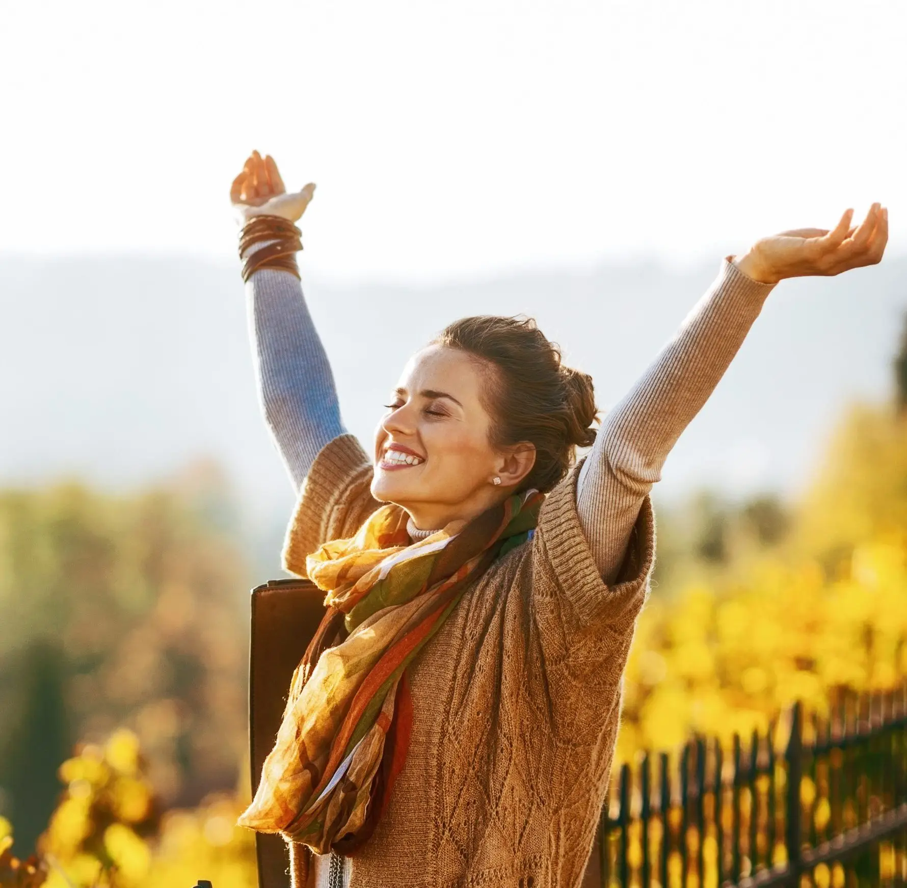 happy young woman in autumn outdoors rejoicing