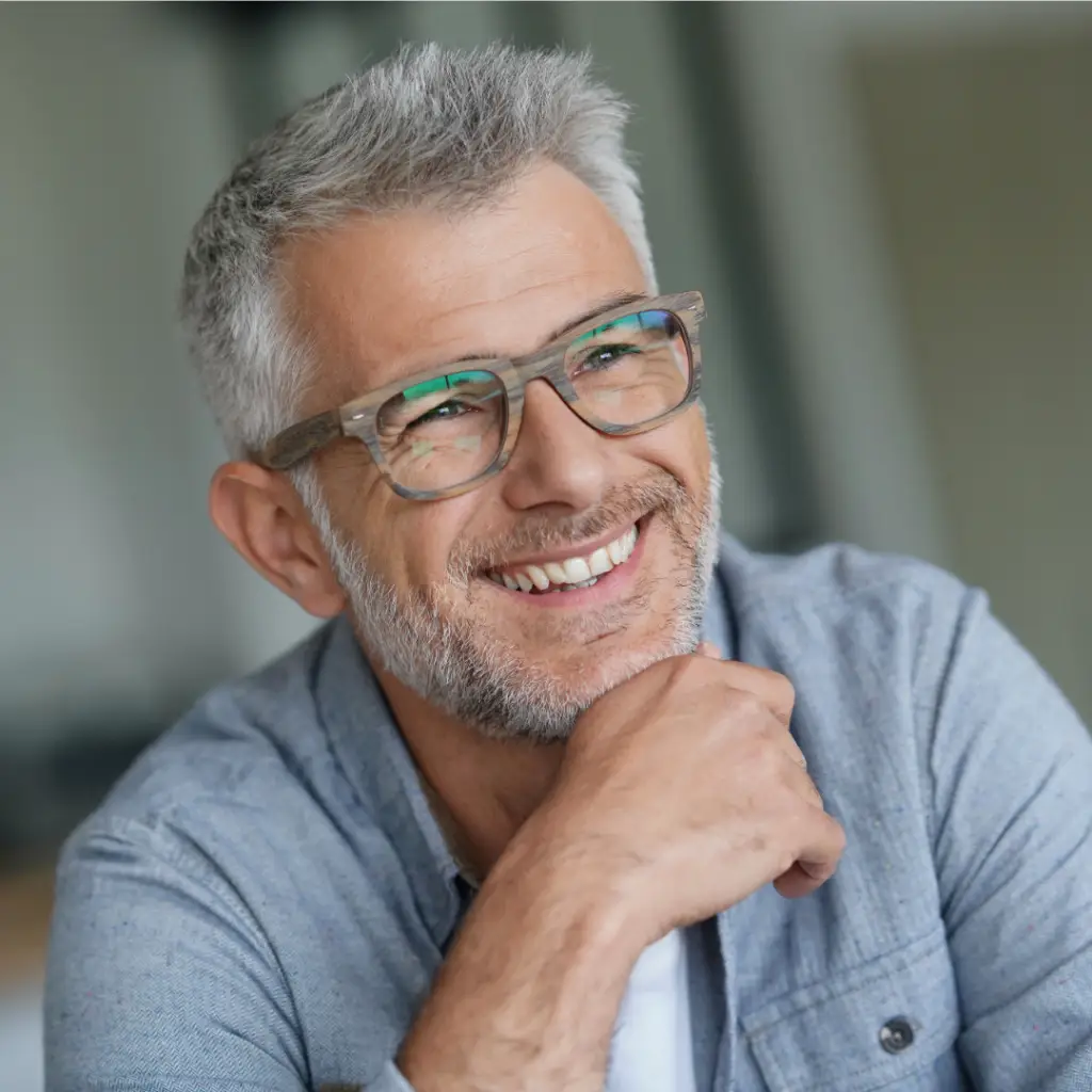 EMDR Therapy. Older gentleman wearing glasses and smiling serenely