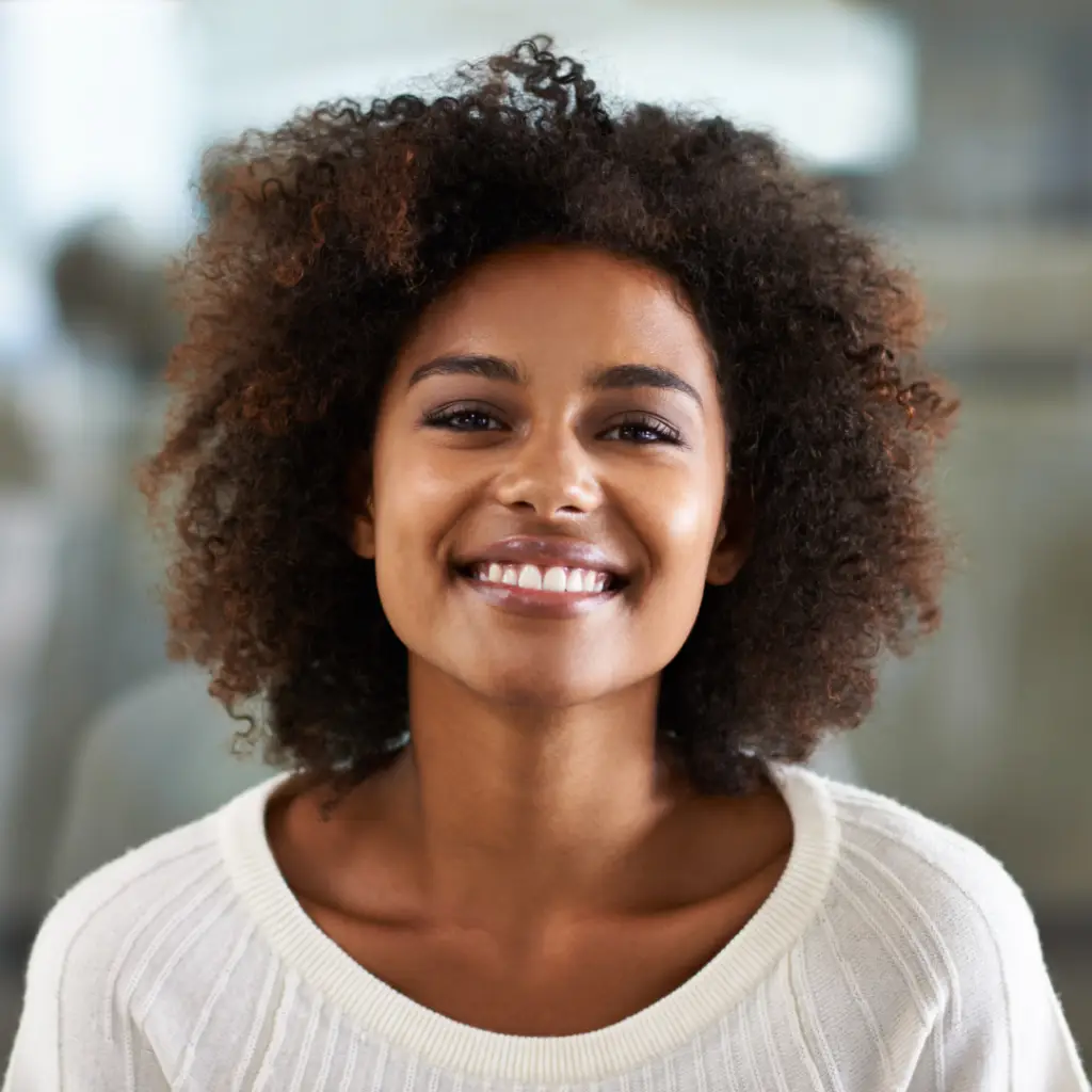 ACT Therapy. Happy woman wearing a white shirt standing and smiling.