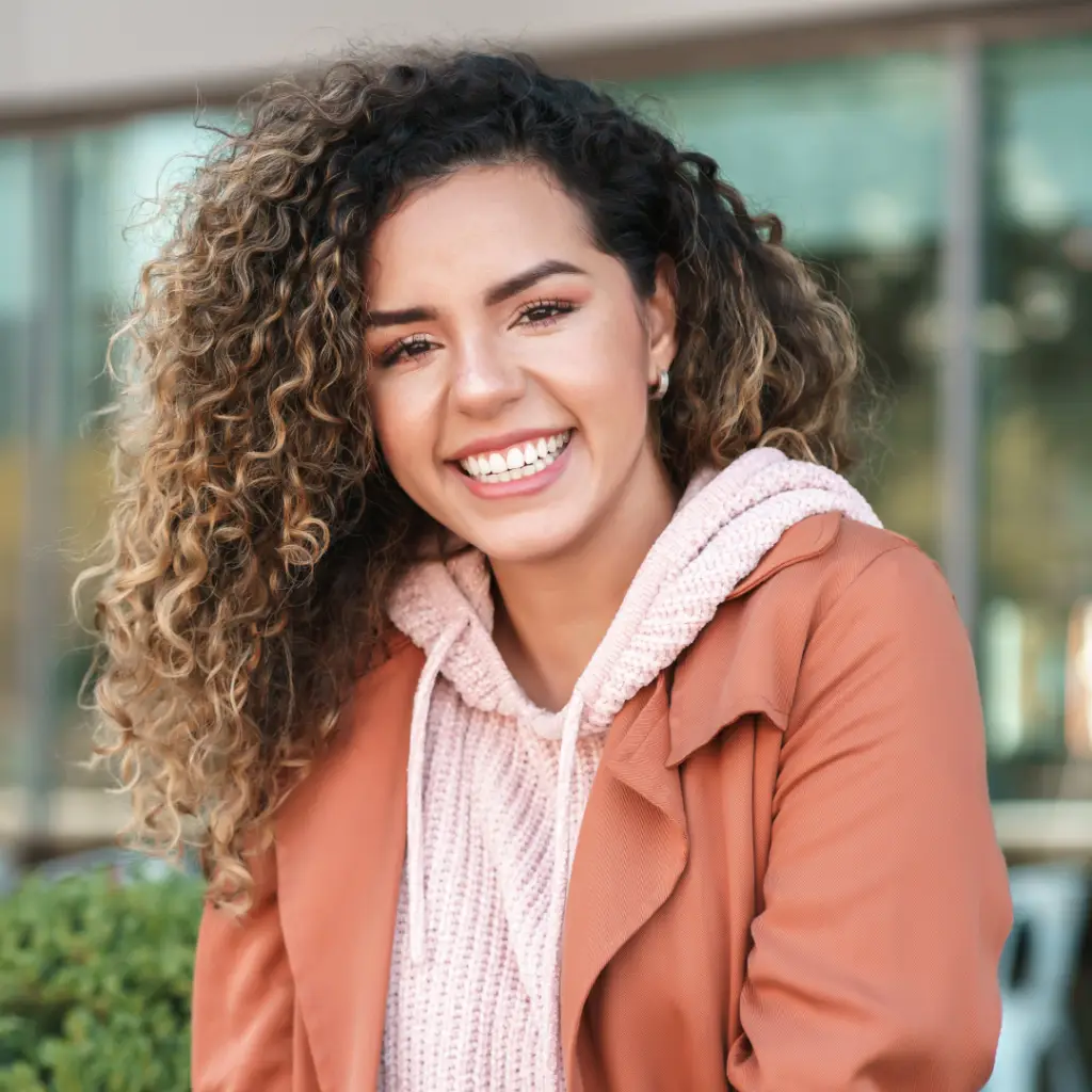 CBIT Therapy. Smiling girl withh curly hair and a pink jacket
