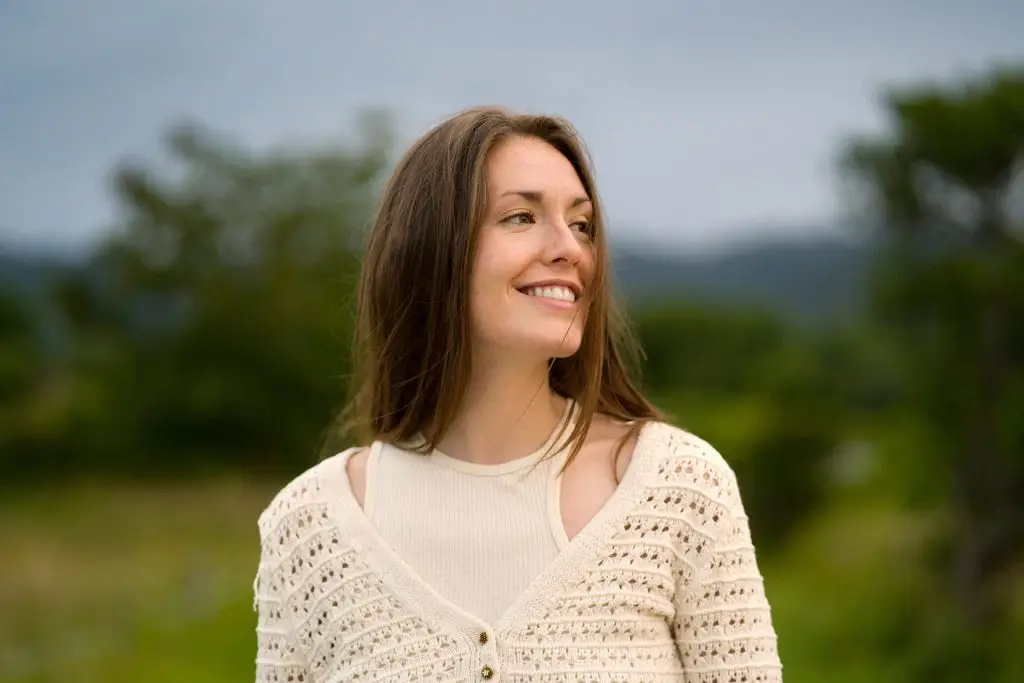 Smiling woman enjoying a peaceful moment outdoors in nature