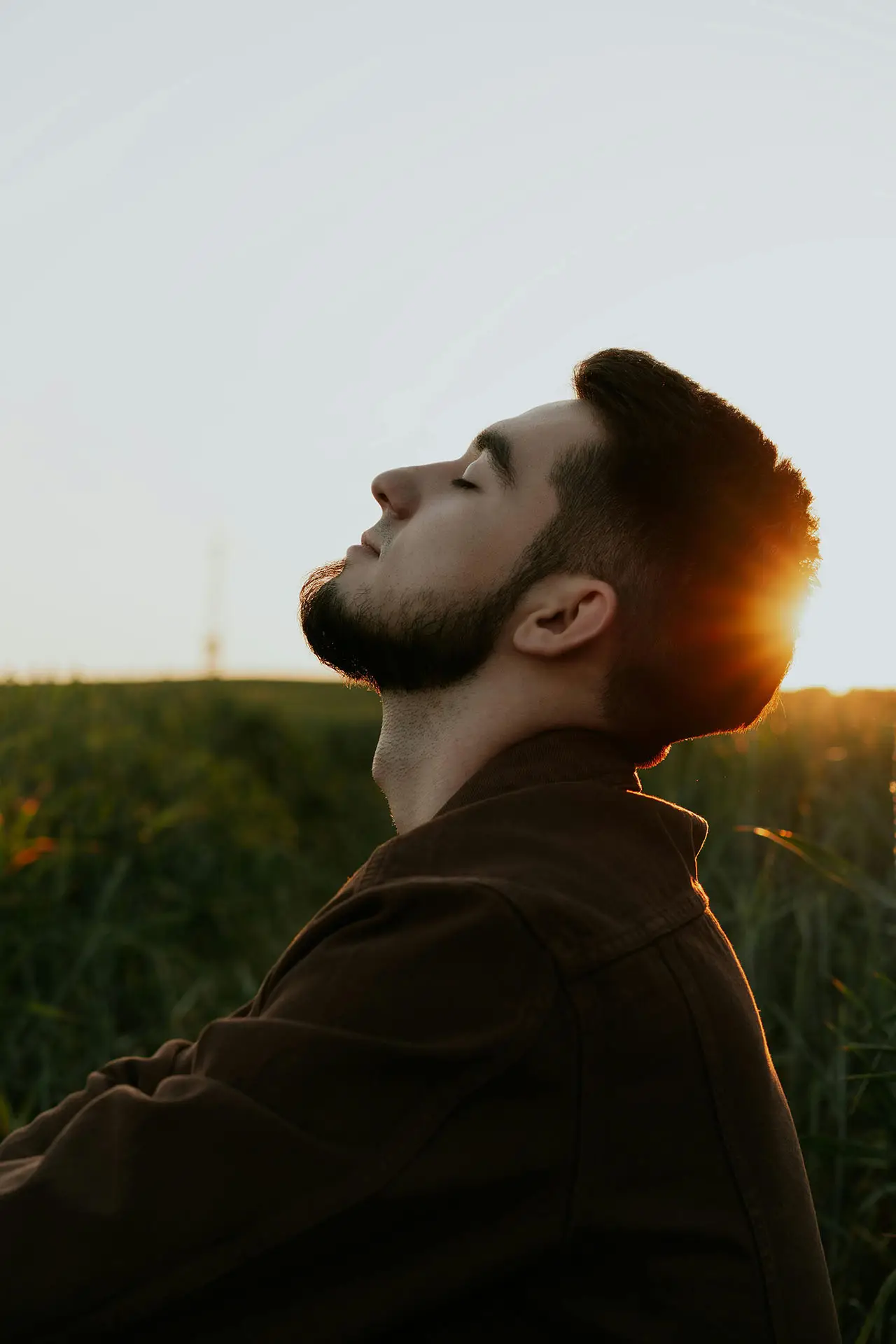 Young man practicing mindfulness outdoors at sunset