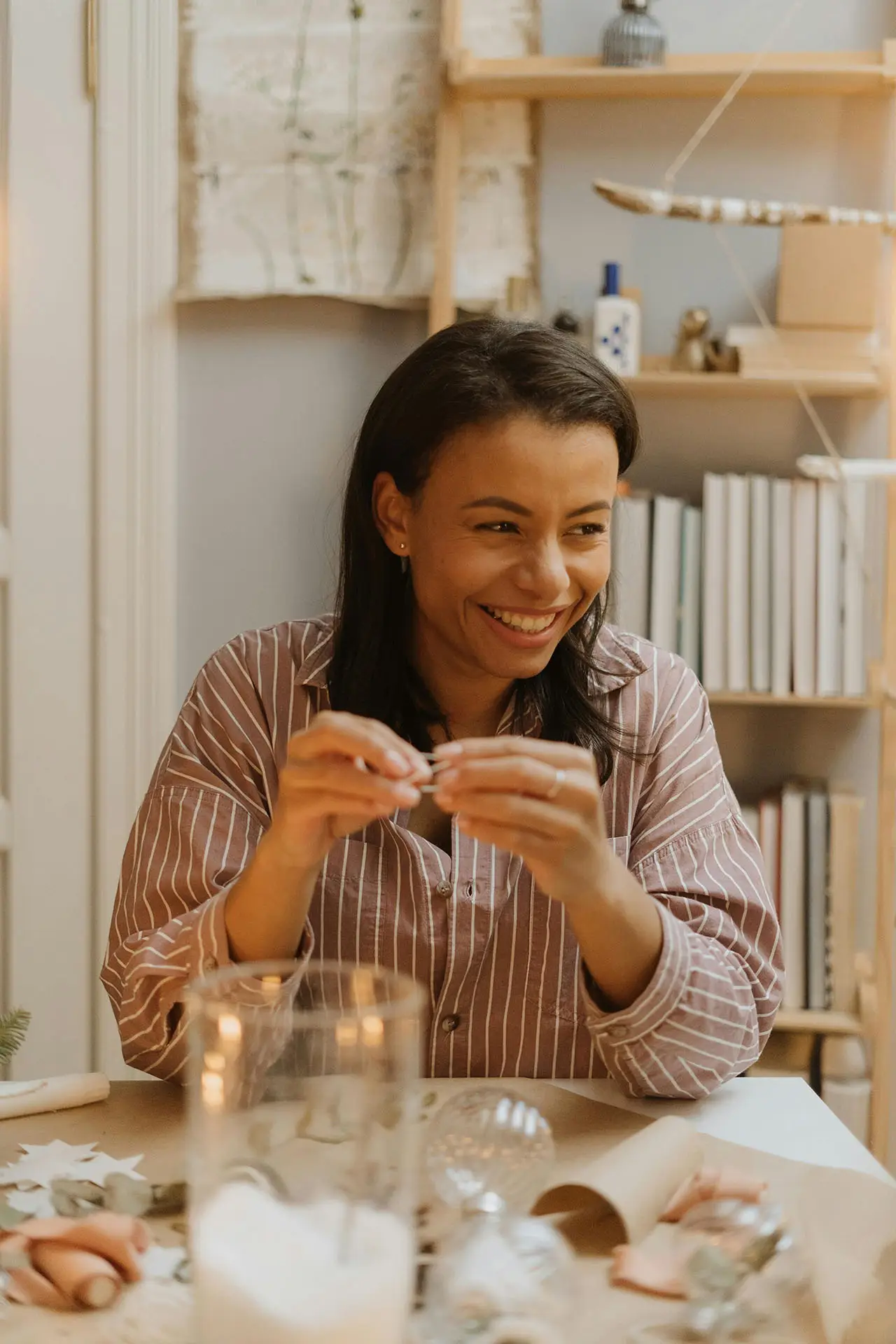 Woman laughing while creating handmade decorations at a table