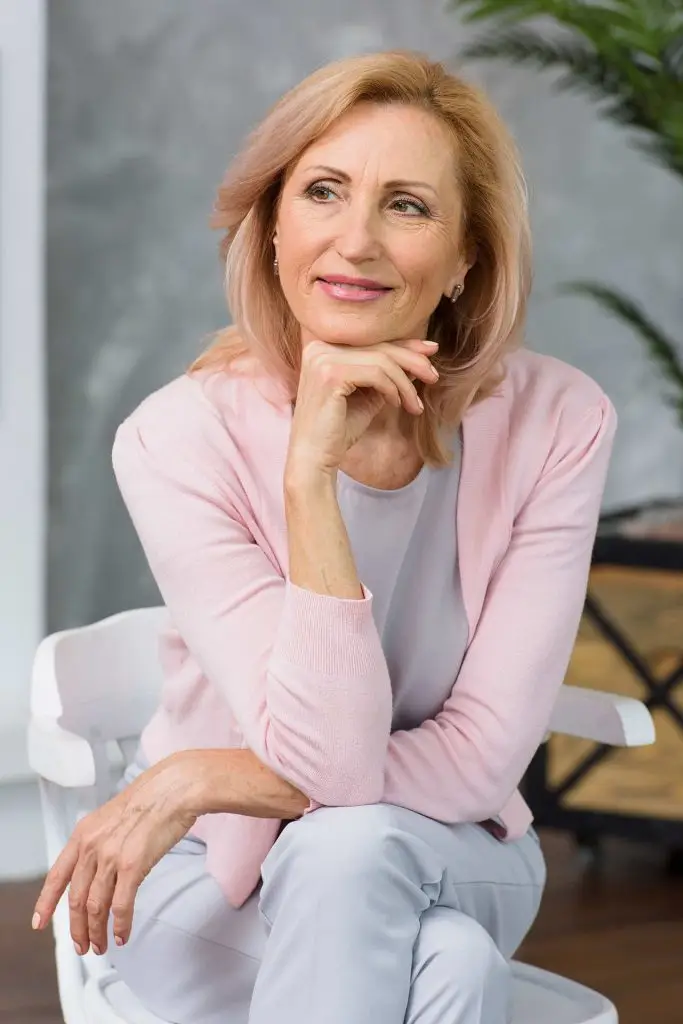 Mature woman smiling while discussing personalized healthcare support with a nurse practitioner